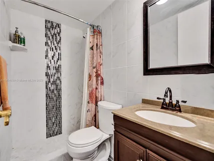 a bathroom with a sink a toilet and shower curtain
