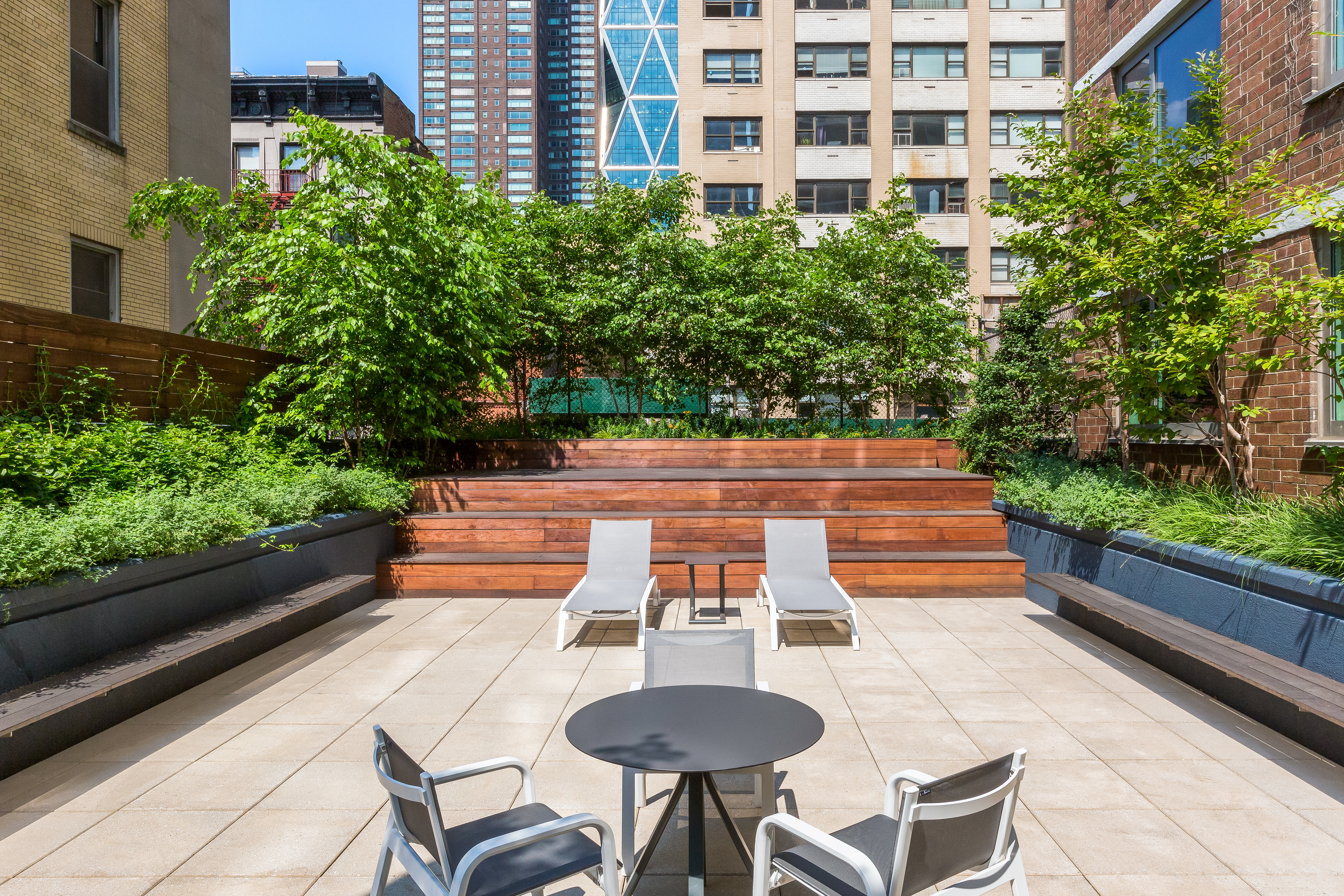 301 West 53rd Street, Unit 13C Manhattan, NY 10019 - Photo 12 of 13 a backyard of a house with table and chairs with plants