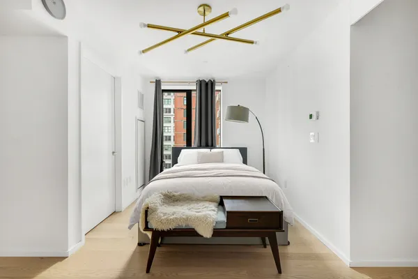 a bedroom with a bed window and chair