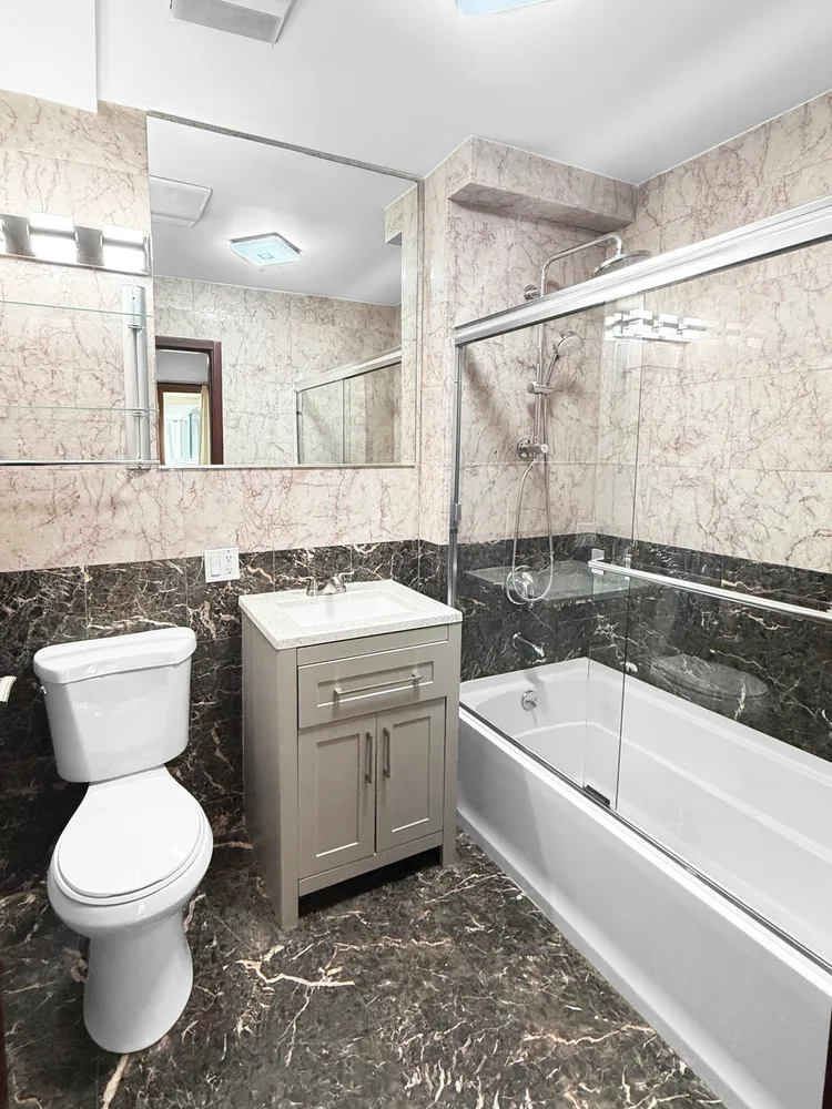 a bathroom with a granite countertop toilet a sink and bathtub