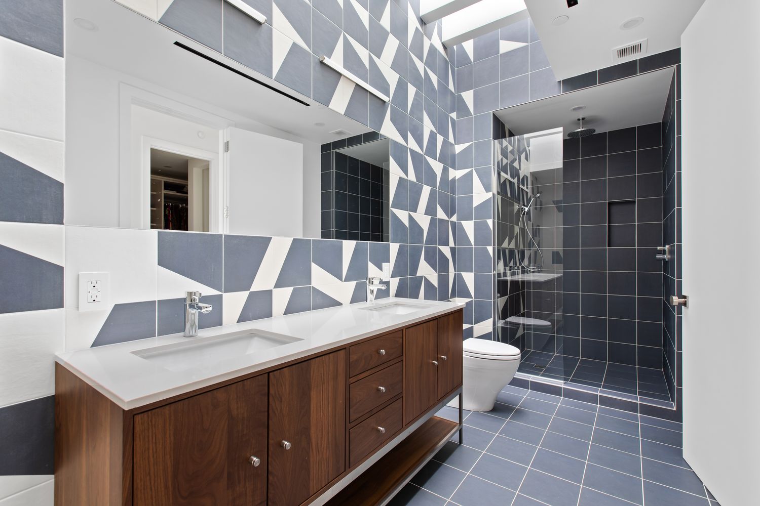 a bathroom with a double vanity sink a toilet and a mirror