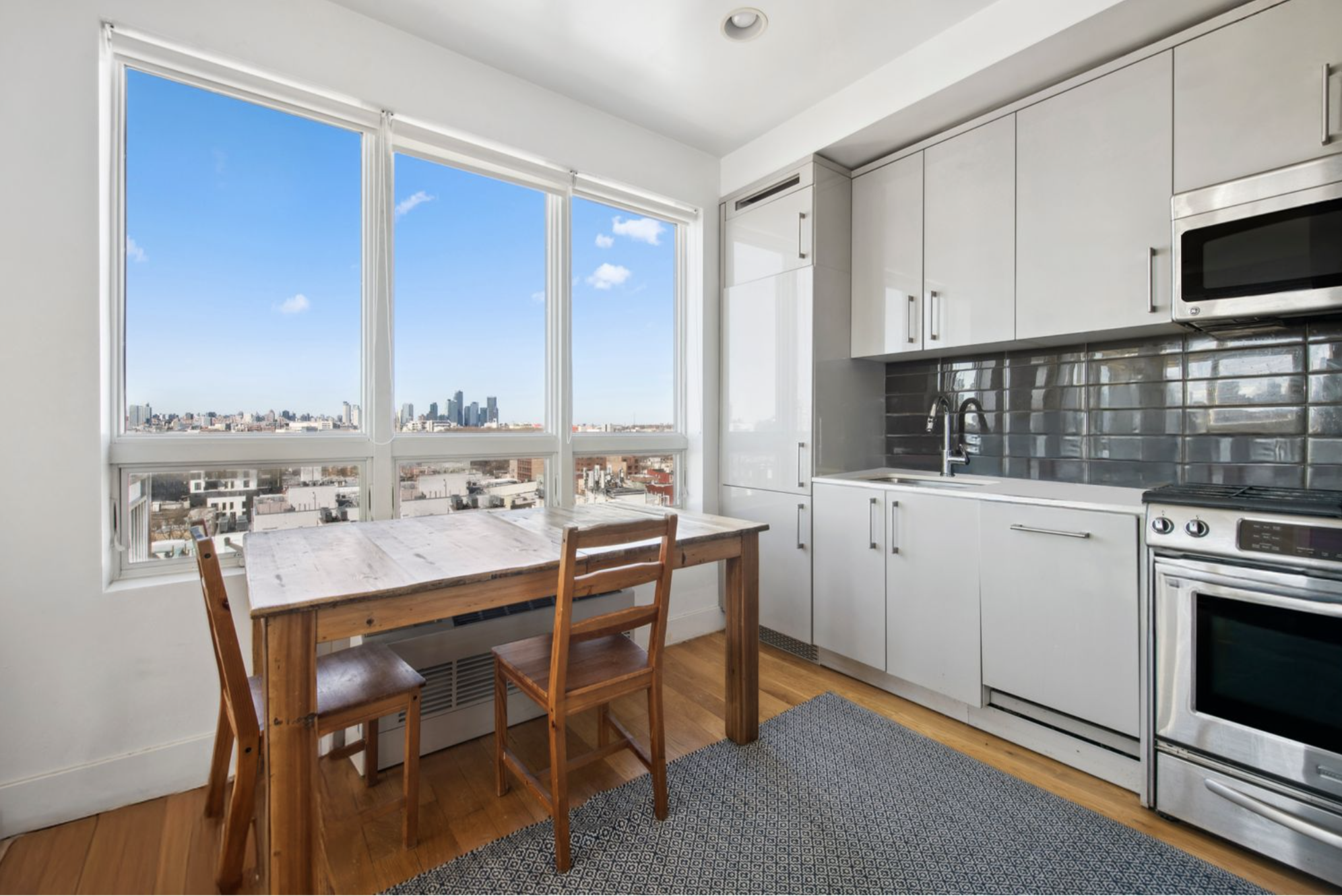 139 Skillman Avenue, Unit 9AB Brooklyn, NY 11211 - Photo 8 of 19 a kitchen with a dining table chairs and white cabinets