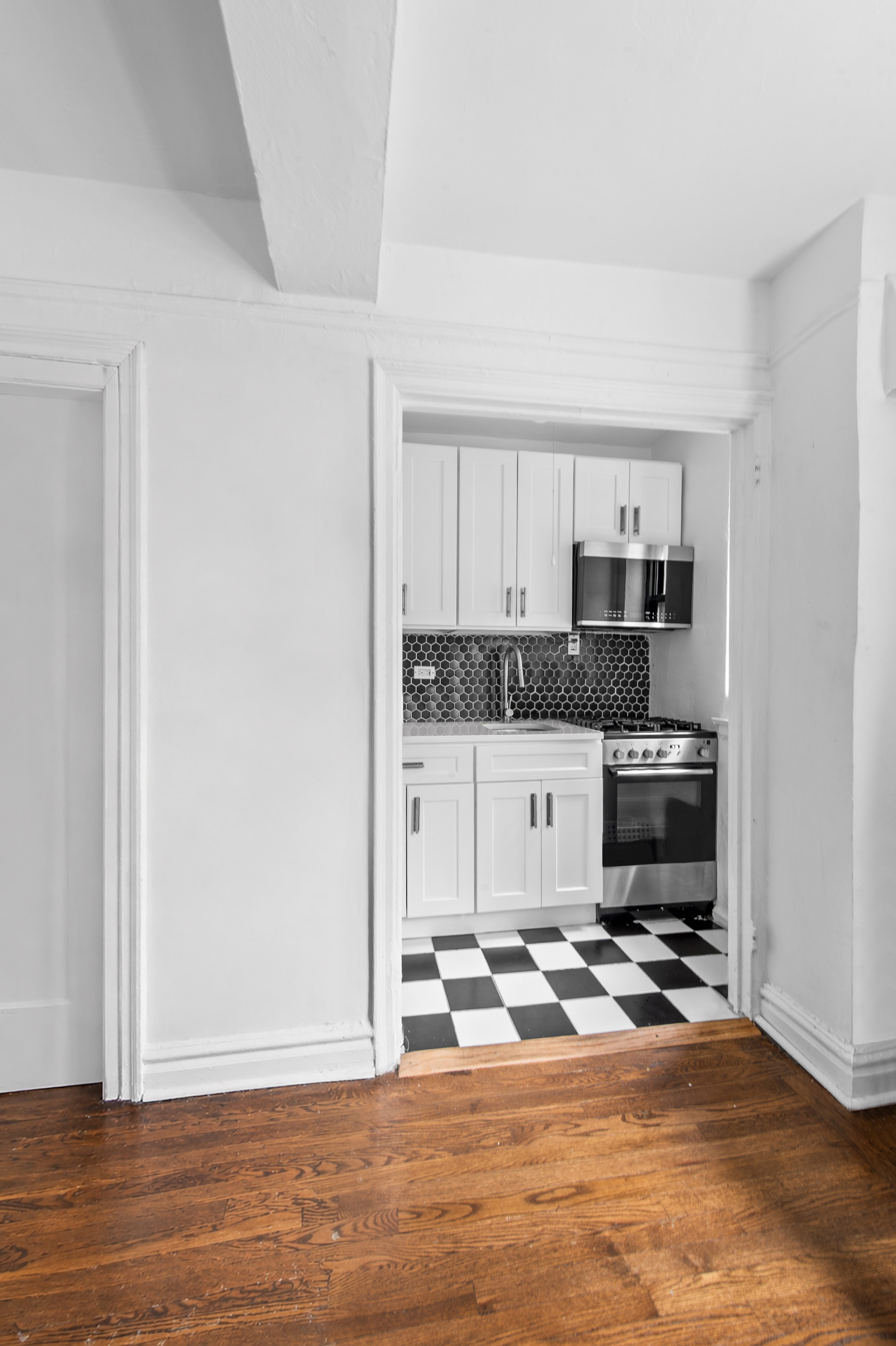 200 East 16th Street, Unit 2A Manhattan, NY 10003 - Photo 6 of 11 a kitchen with a stove and white cabinets