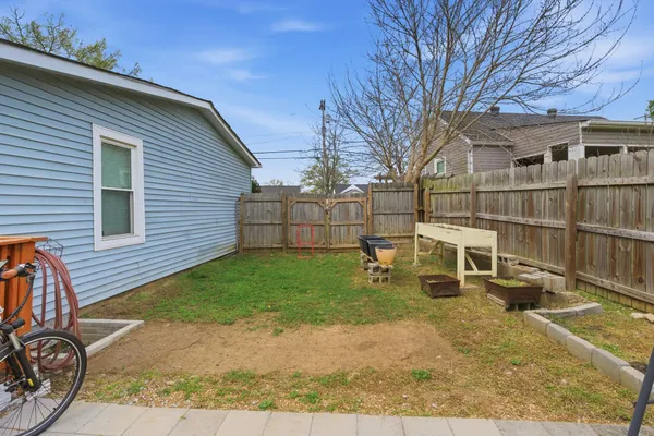 a view of a backyard with table and chairs and a barbeque