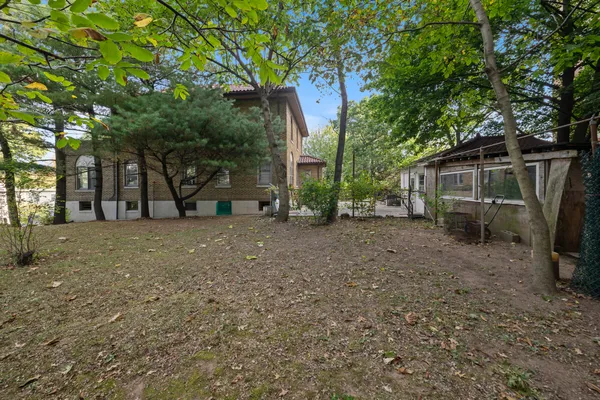 a view of house with backyard and trees