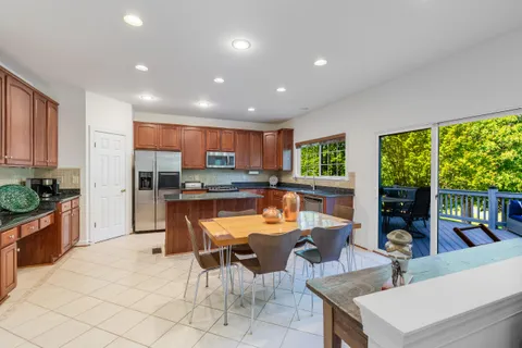a kitchen with stainless steel appliances kitchen island granite countertop a table and chairs