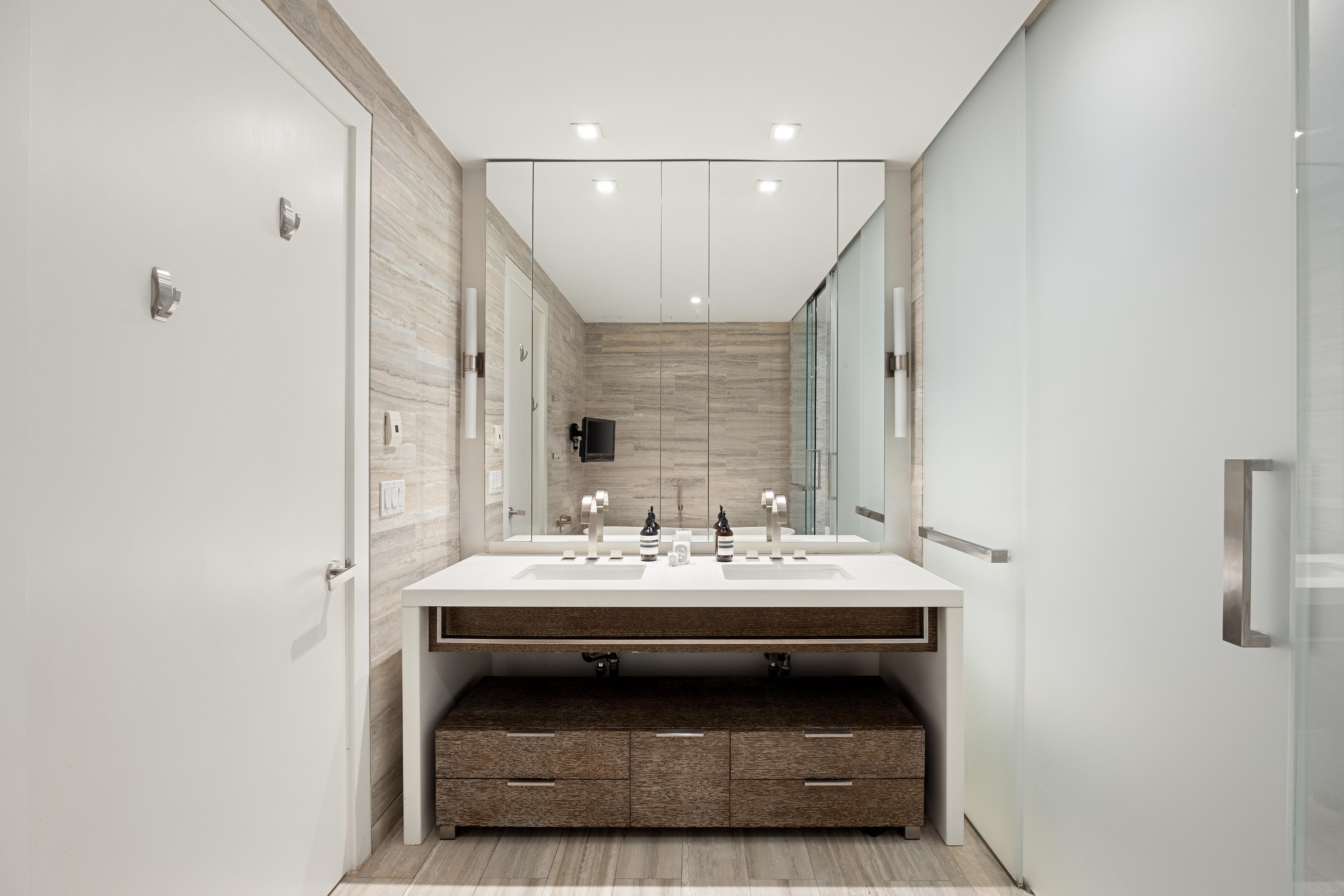 400 West 12th Street, Unit 4J Manhattan, NY 10014 - Photo 7 of 21 a en suite bathroom with a sink and a mirror