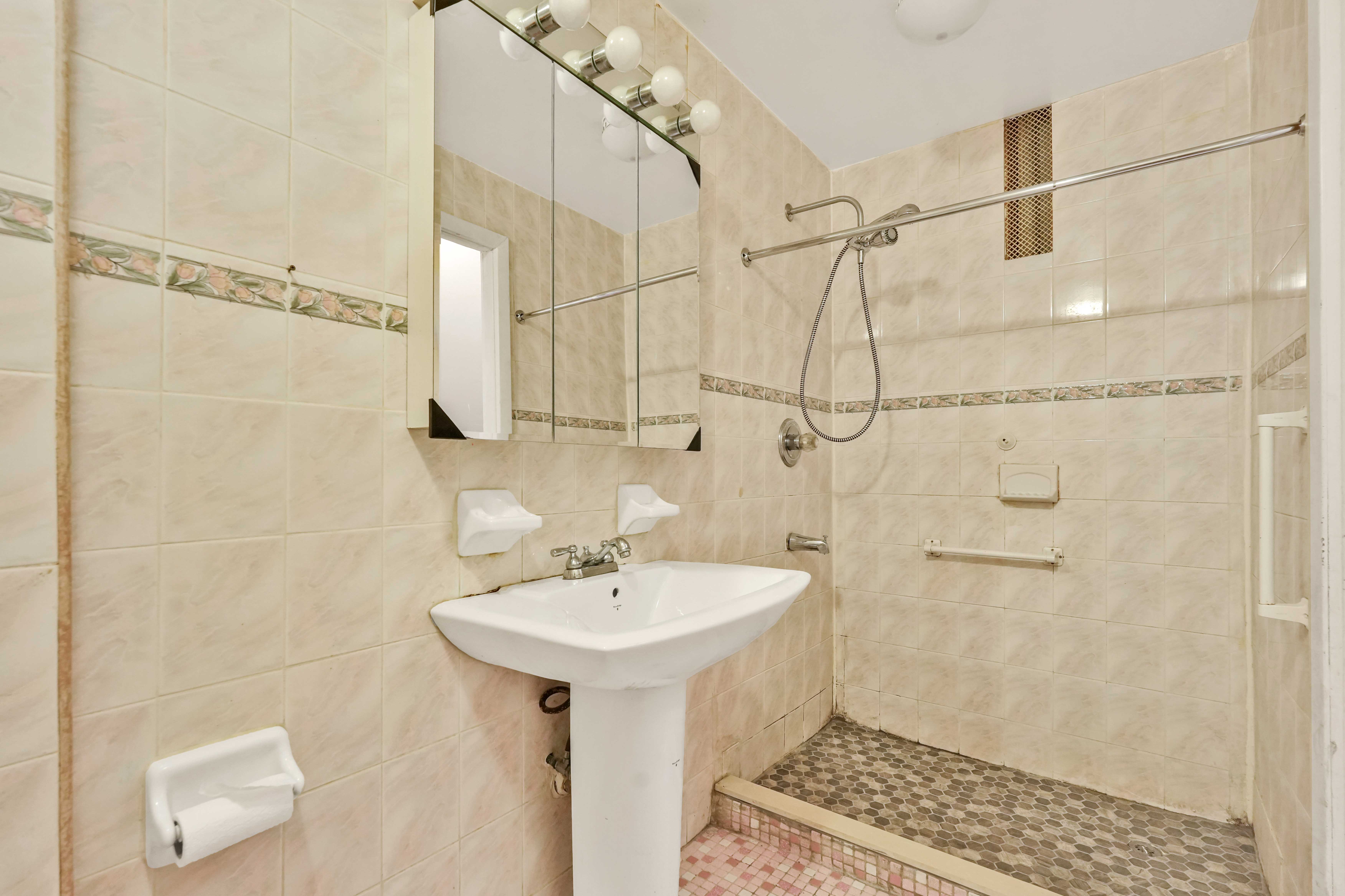 278 Lefferts Avenue Brooklyn, NY 11225 - Photo 32 of 56 a bathroom with a sink a mirror and shower