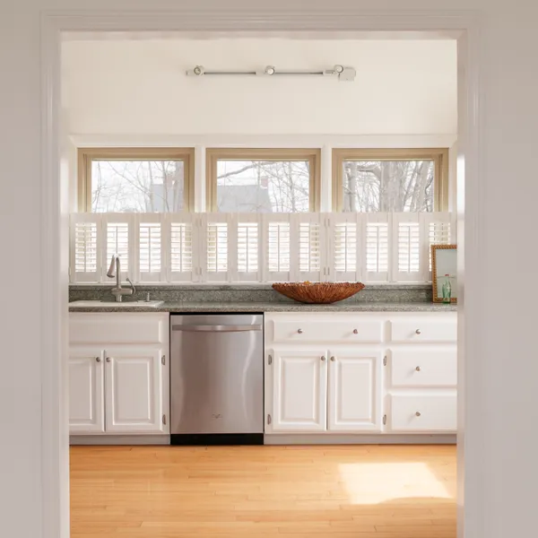 a kitchen with granite countertop white cabinets and a window