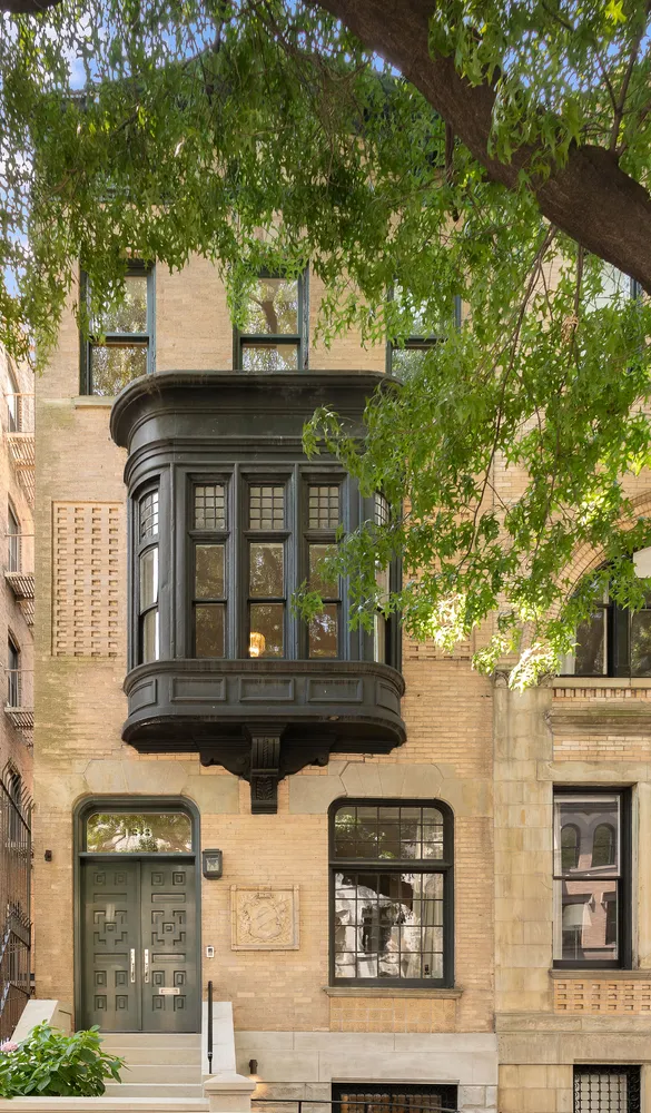 a front view of a house with a tree
