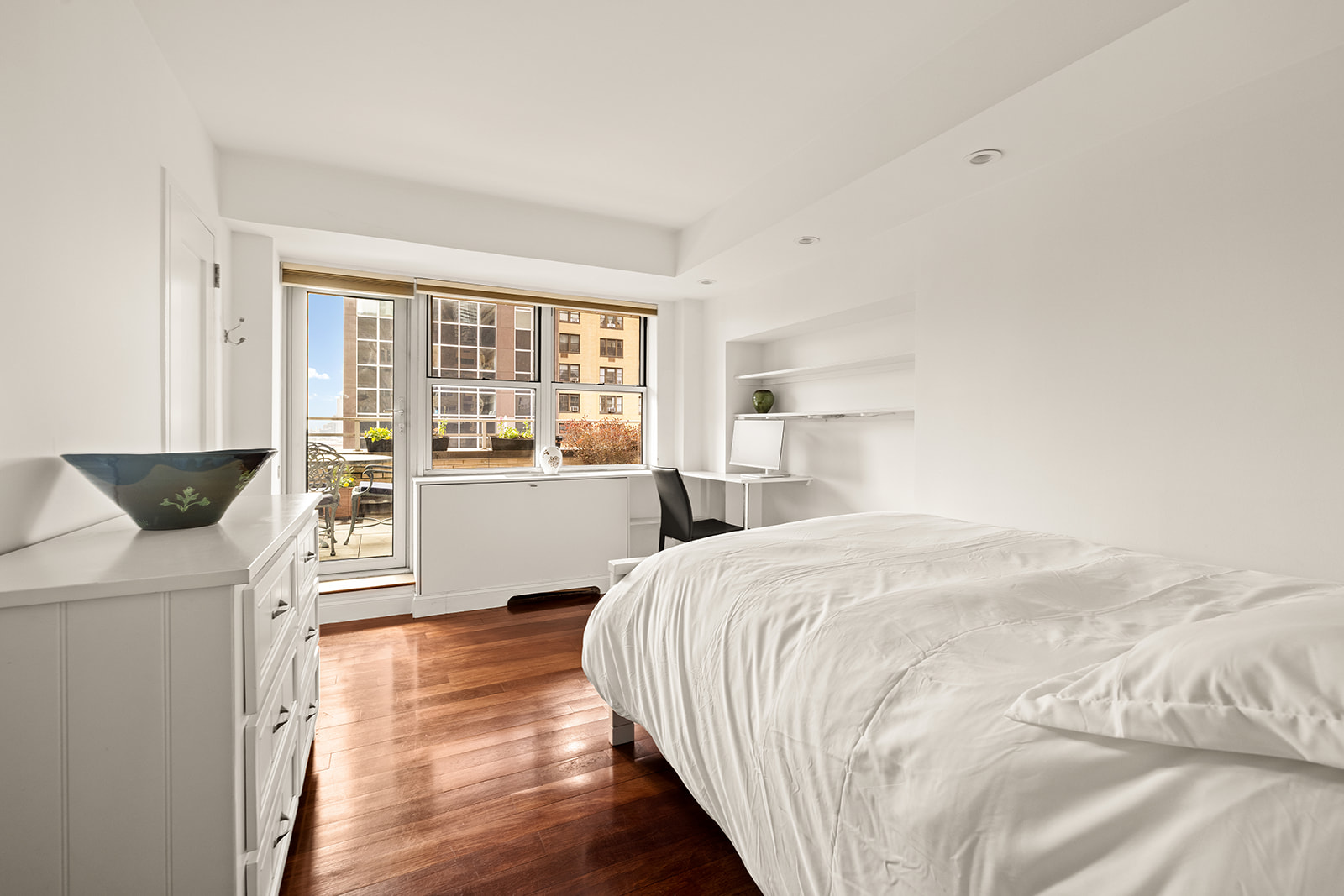 330 East 49th Street, Unit 12E Manhattan, NY 10017 - Photo 10 of 16 a bedroom with a bed and wooden floor