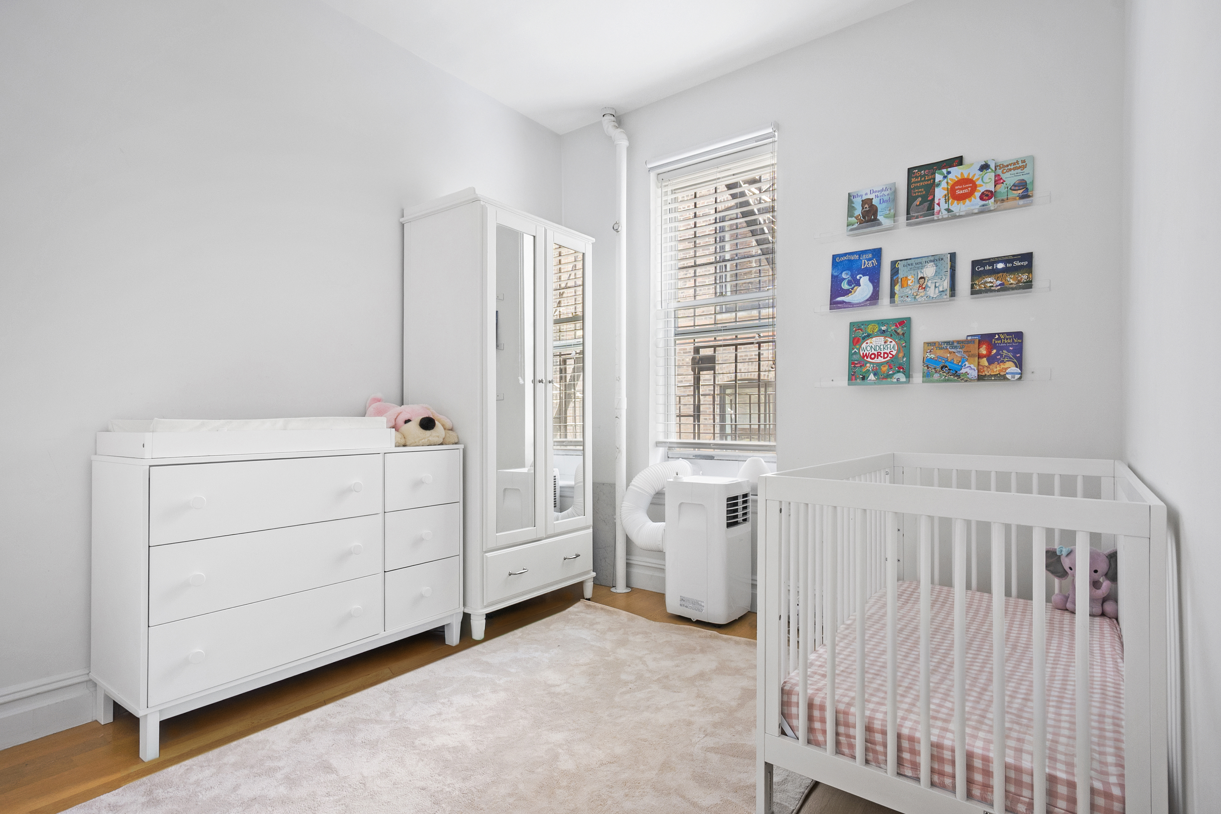 345 West 70th Street, Unit 5E Manhattan, NY 10023 - Photo 6 of 10 a view of a bedroom with baby crib and a window