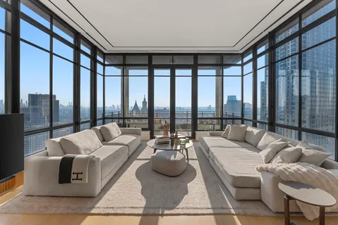 a living room with furniture and floor to ceiling windows
