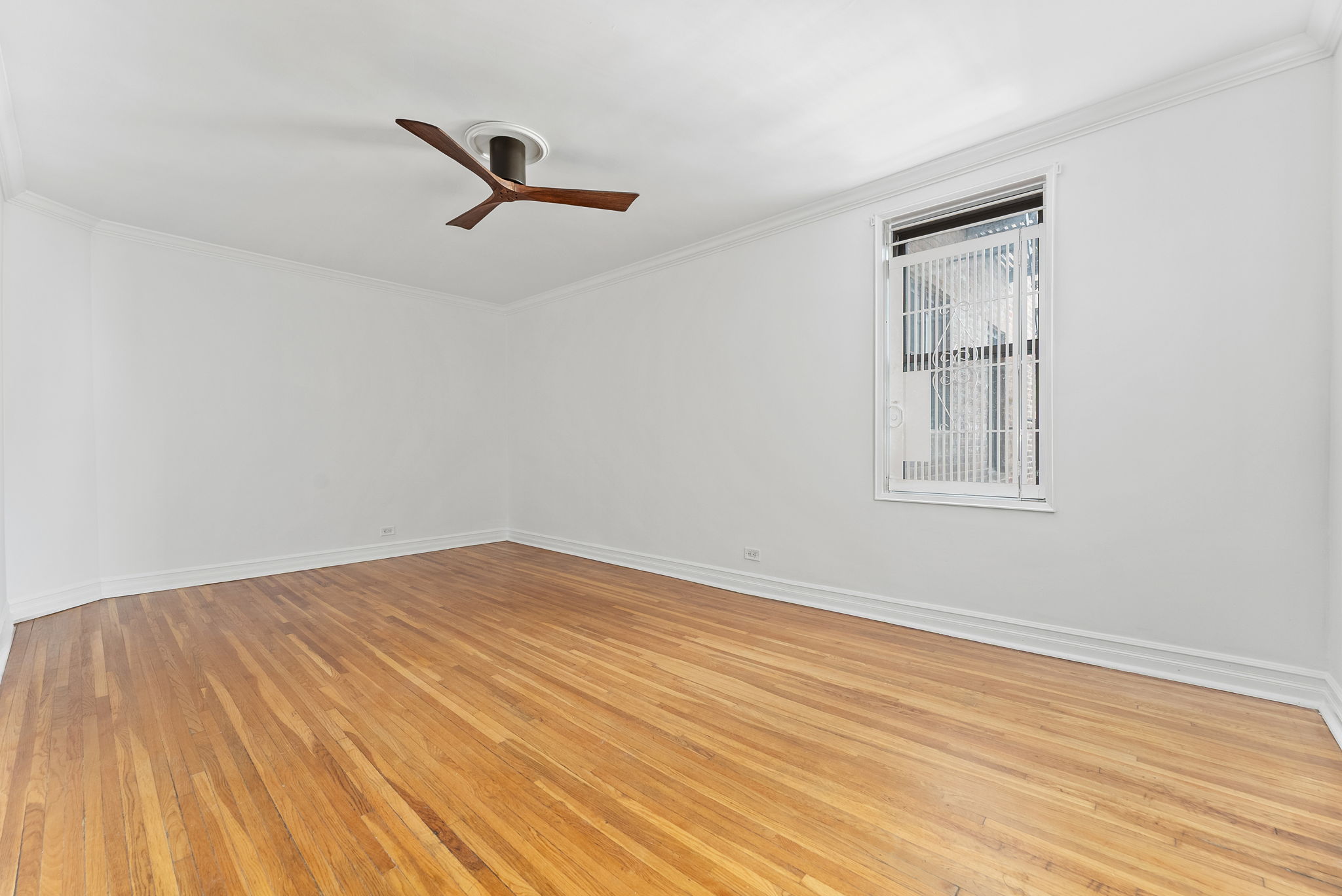 675 Academy Street, Unit 3A Manhattan, NY 10034 - Photo 5 of 12 a view of empty room with wooden floor and fan