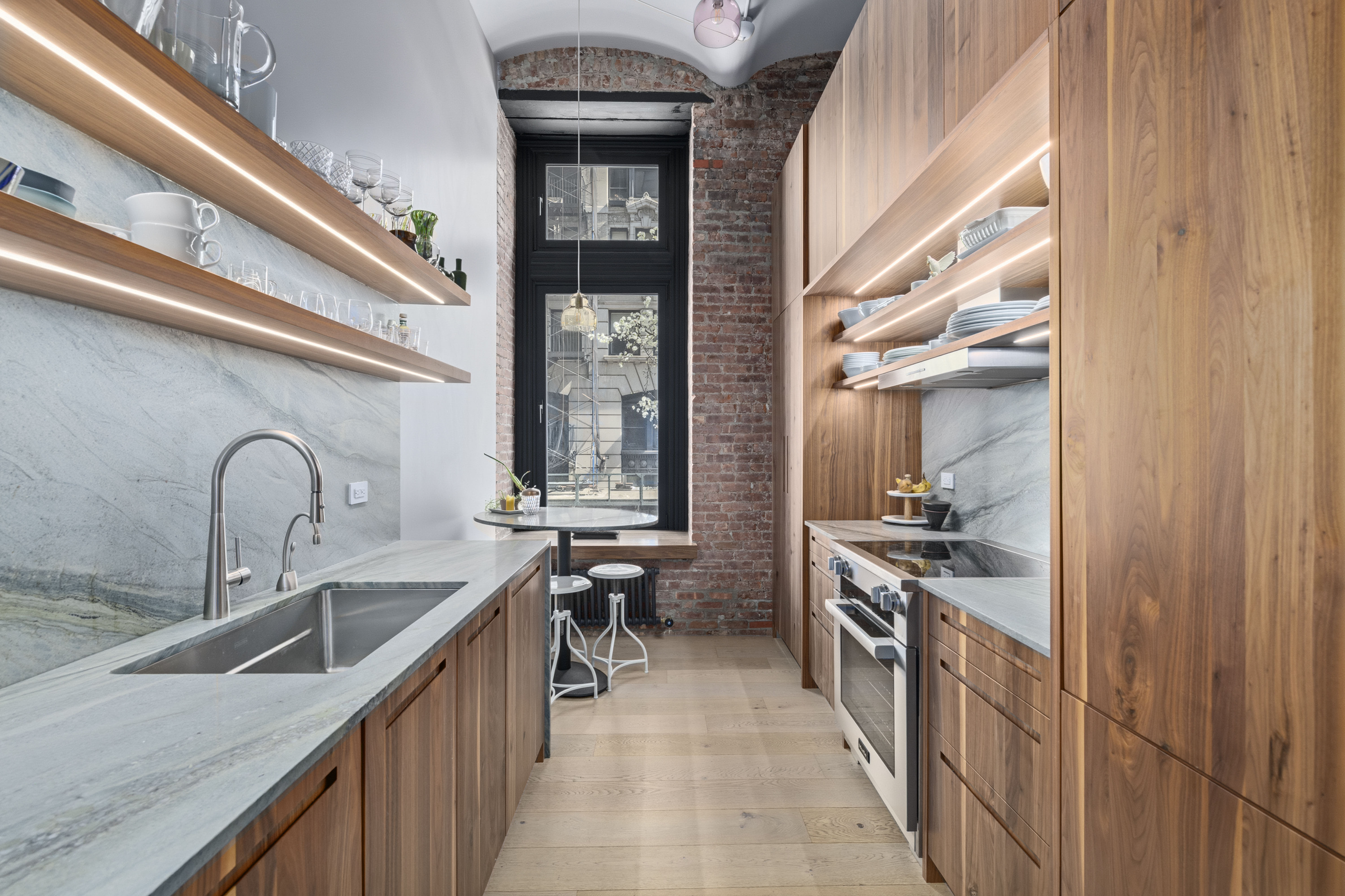 1 Great Jones St, Unit 2B Manhattan, NY 10012 - Photo 6 of 12 a kitchen with stainless steel appliances granite countertop a sink and a stove