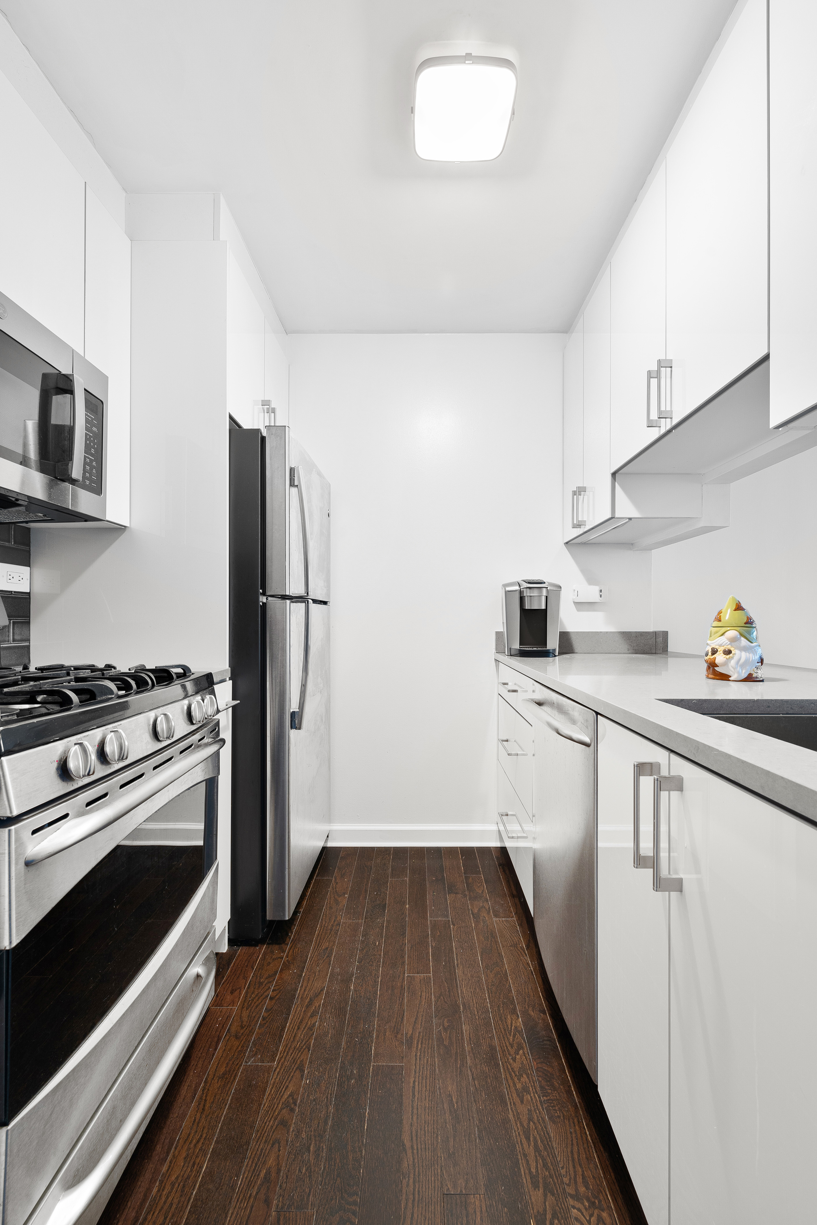445 5th Avenue, Unit 26F Manhattan, NY 10016 - Photo 4 of 11 a kitchen with a refrigerator stove and wooden cabinets