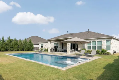 a view of a house with swimming pool and a table and chairs