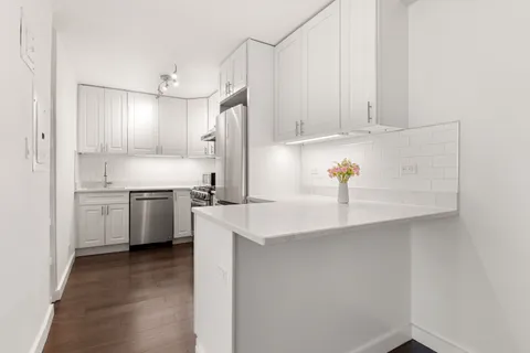 a kitchen with white cabinets and white appliances