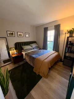 a bedroom with a bed next to a window