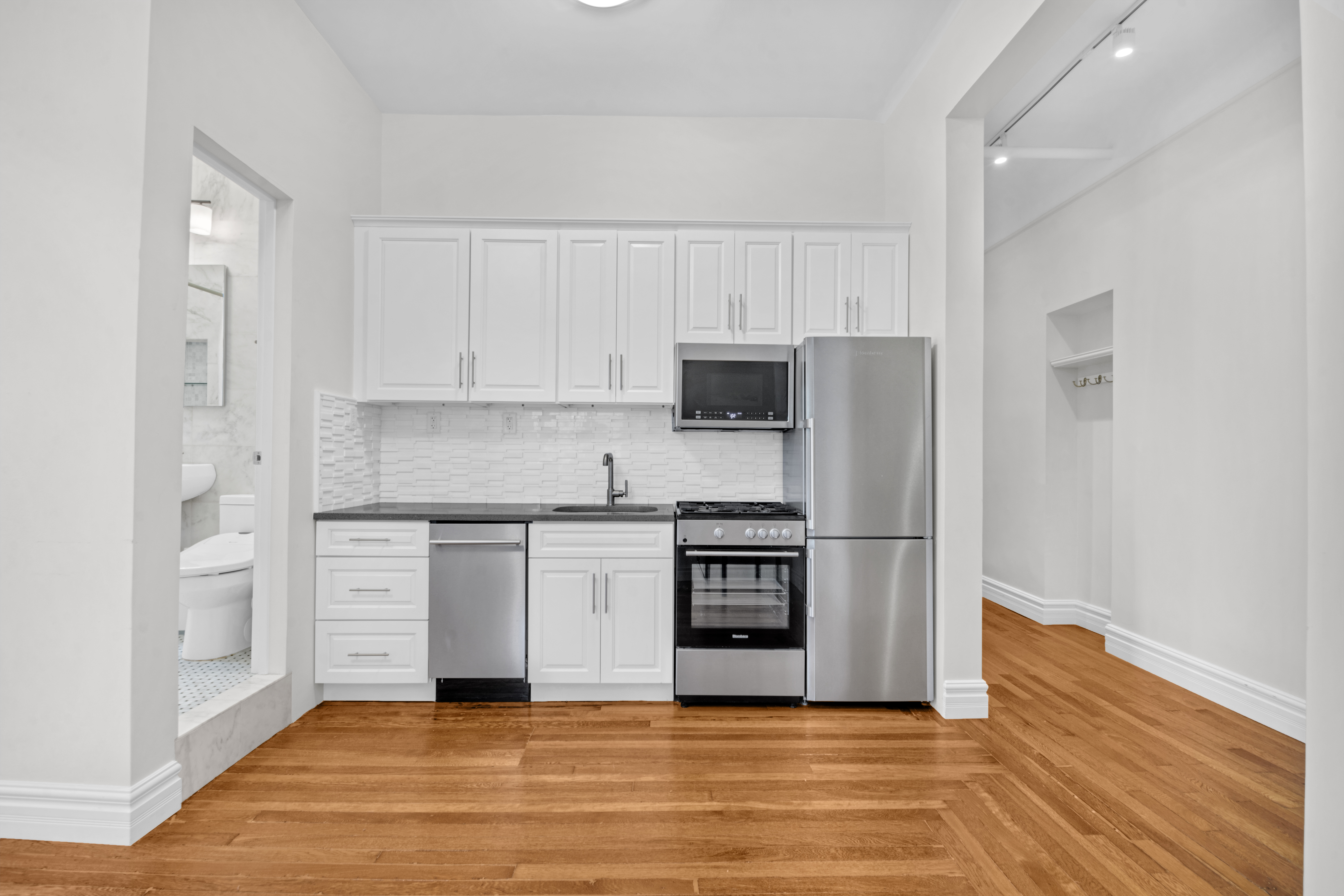 244 Riverside Drive, Unit 2F Manhattan, NY 10025 - Photo 4 of 8 a kitchen with granite countertop a stove top oven and cabinets