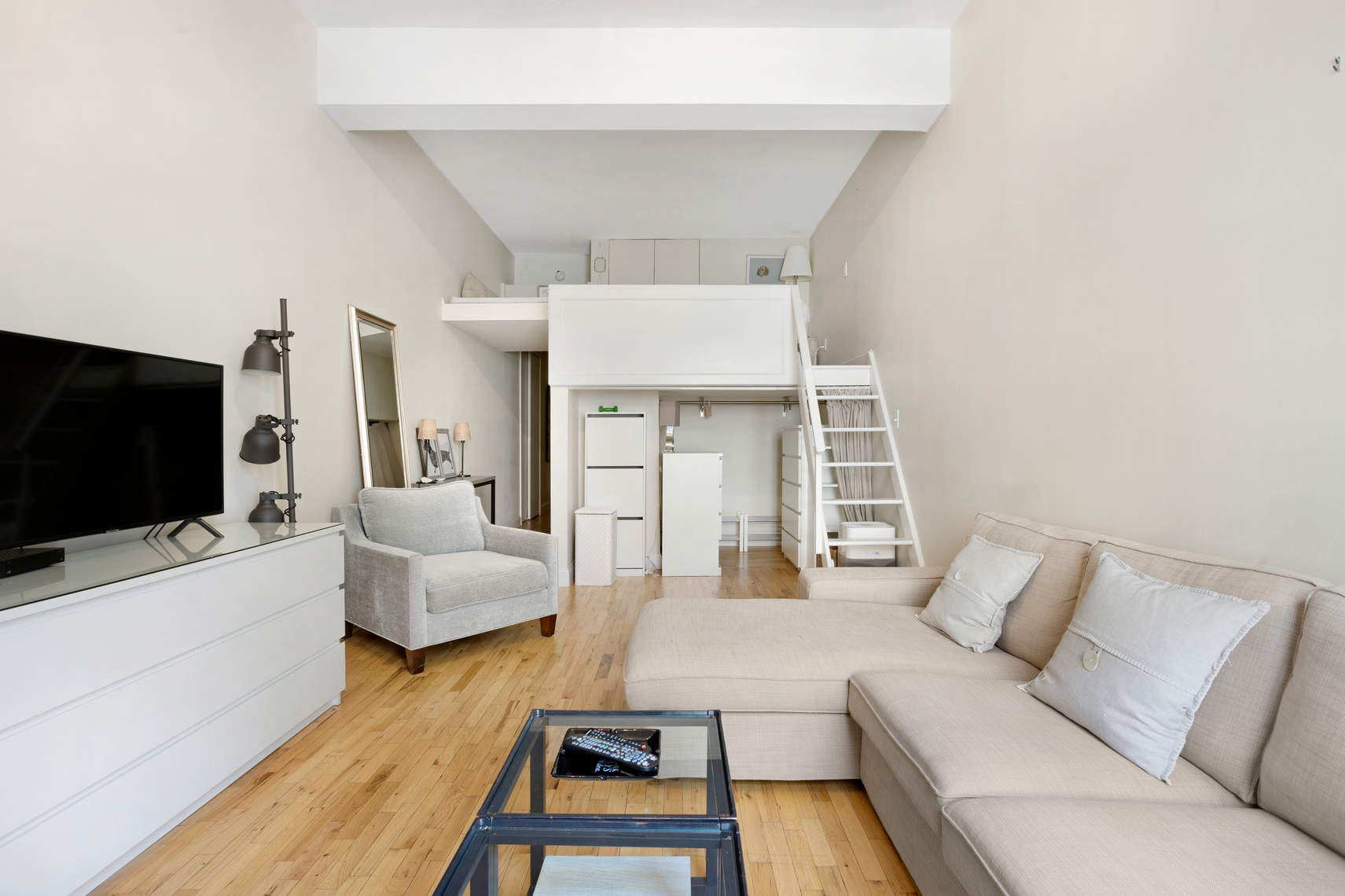 310 East 23rd Street, Unit 7C Manhattan, NY 10010 - Photo 7 of 18 a living room with furniture and a flat screen tv