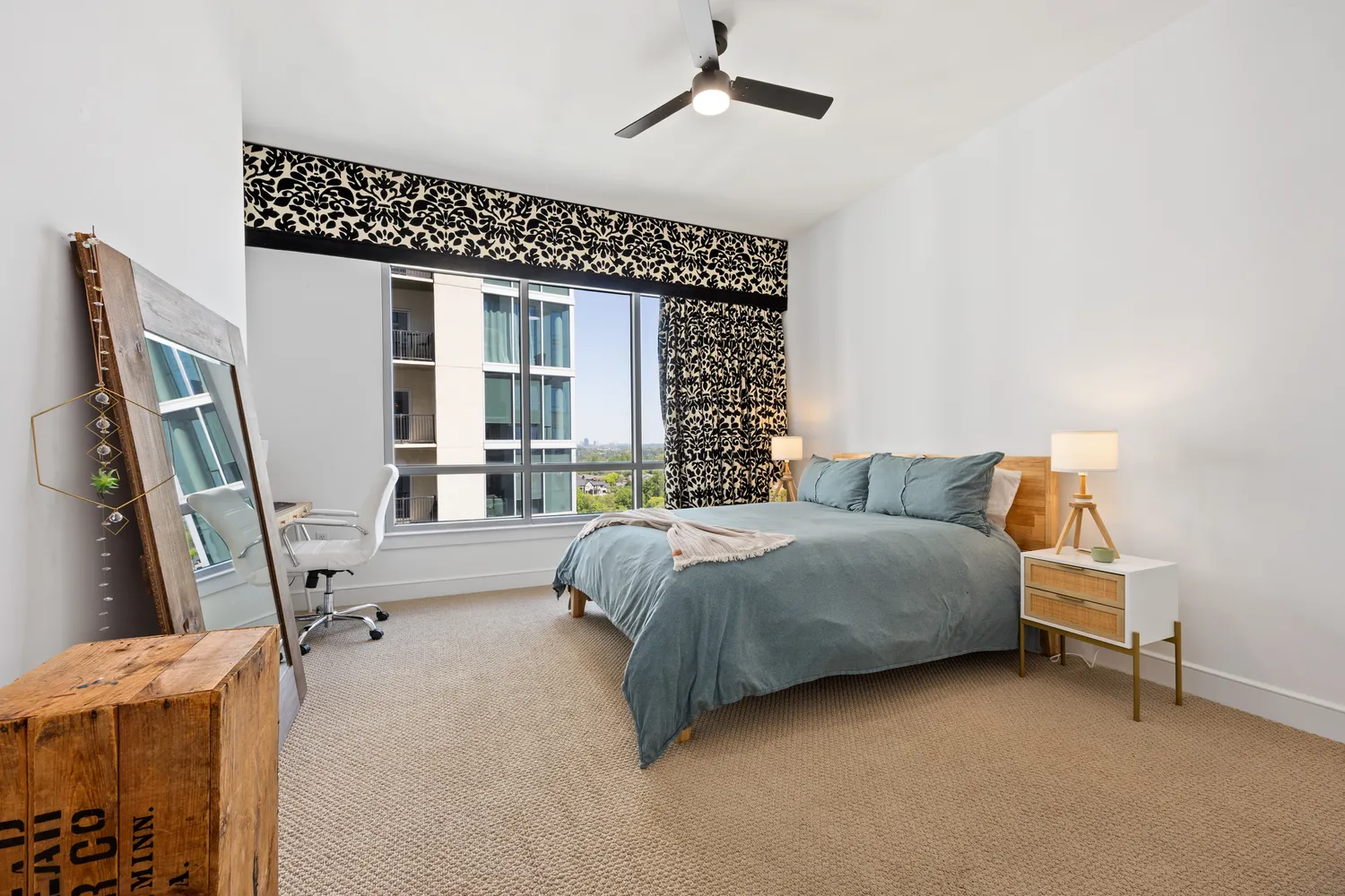 a spacious bedroom with a bed couch and a window