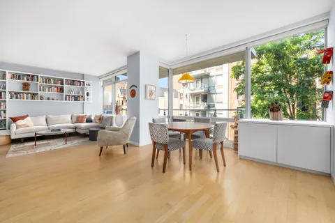 a dining room with furniture and a large window