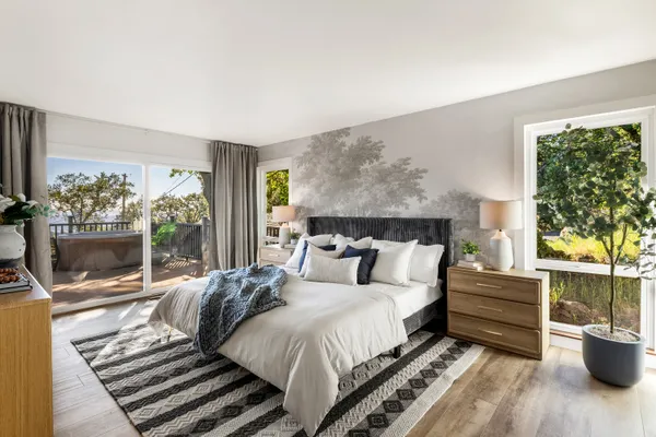 a bedroom with a bed a flat screen tv and balcony view