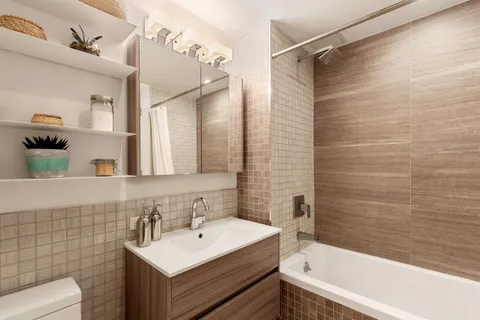 a bathroom with a sink mirror toilet and bathtub