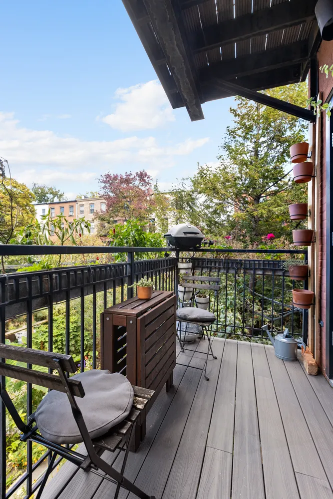 a view of a balcony with wooden floor and outdoor seating