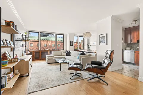 a living room with furniture floor to ceiling window and a flat screen tv