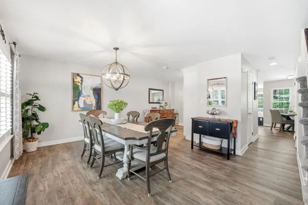 a view of a dining room with furniture wooden floor and a chandelier