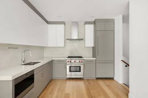 a kitchen with a sink a stove and cabinets