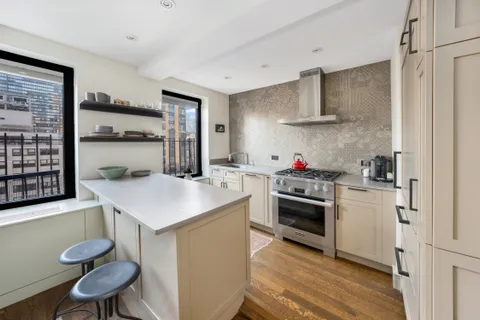 a kitchen with stainless steel appliances a stove a sink dishwasher and cabinets with wooden floor