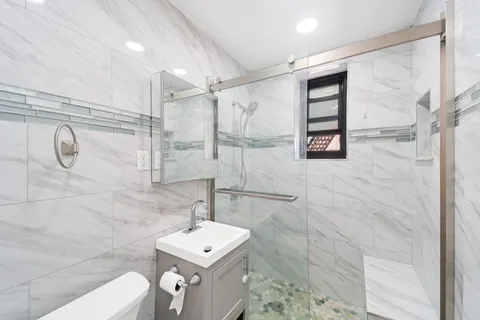 a bathroom with a shower a mirror and a sink
