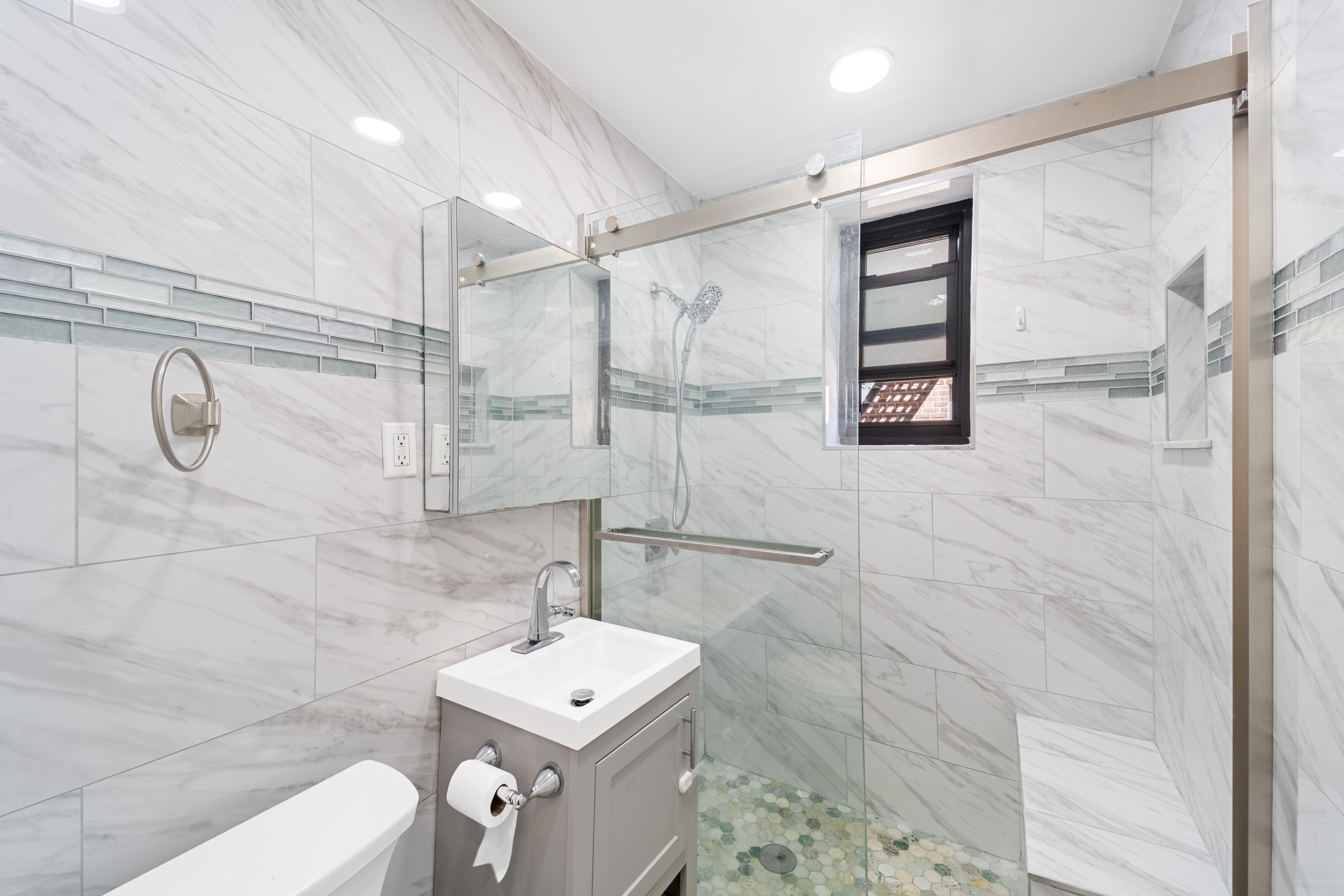 211-01 75th Avenue, Unit 4O Queens, NY 11364 - Photo 16 of 19 a bathroom with a shower a mirror and a sink