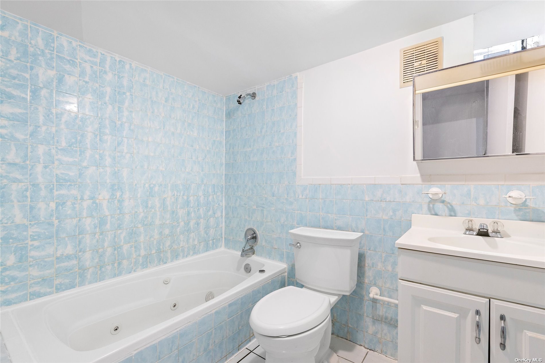 85-23 Edgerton Boulevard Queens, NY 11432 - Photo 28 of 36 a bathroom with a toilet a sink a mirror and bathtub