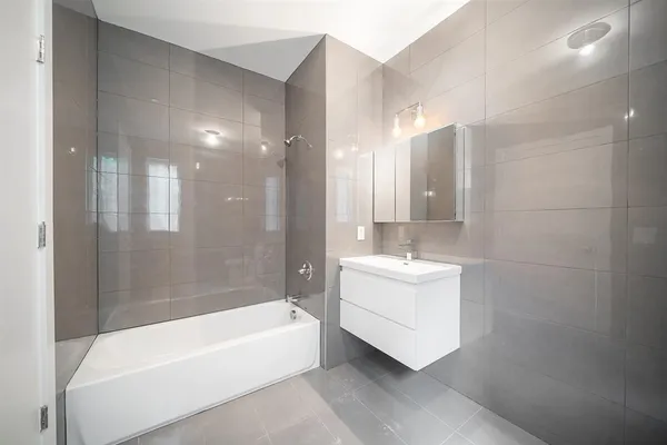 a bathroom with a bathtub a sink a mirror and a shower