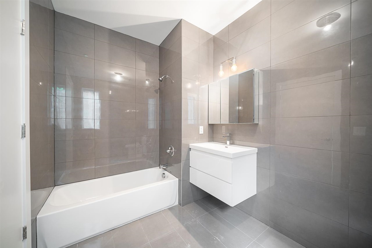 8621 River Road, Unit 6D North Bergen, NJ 07047 - Photo 22 of 36 a bathroom with a bathtub a sink a mirror and a shower