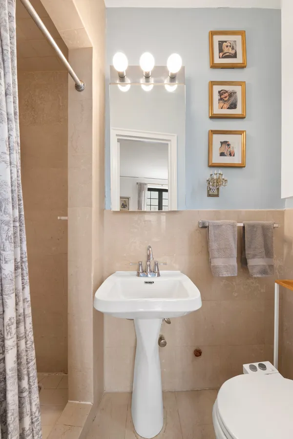 a bathroom with a sink toilet and a mirror