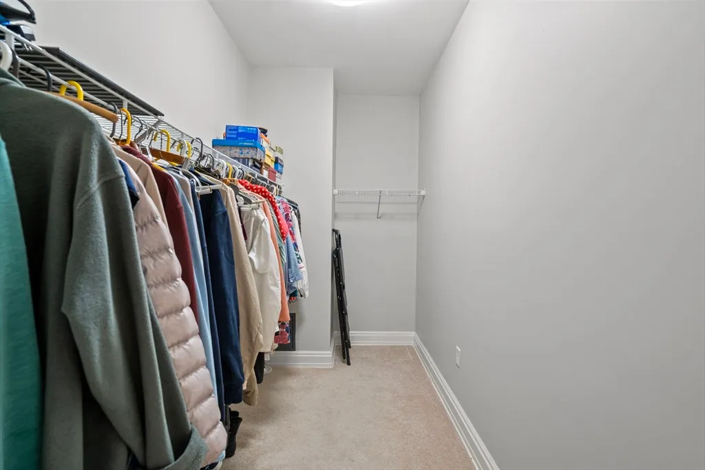 a view of walk in closet with clothes