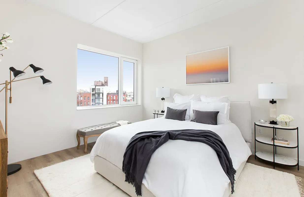 a bedroom with a bed and a lamp with the wooden floor