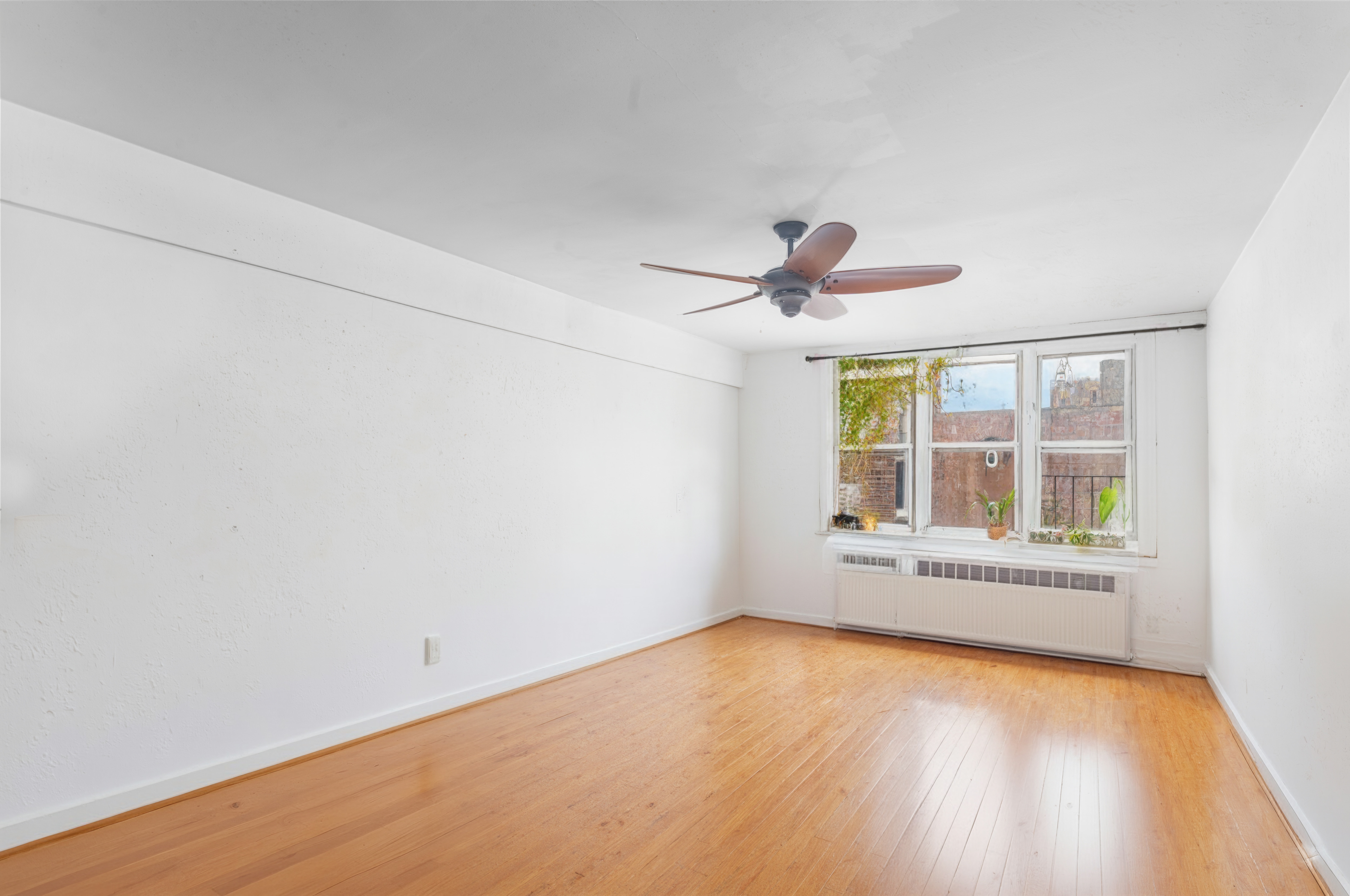 227 Ocean Parkway, Unit 7F Brooklyn, NY 11218 - Photo 3 of 7 an empty room with wooden floor and windows