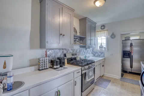 a kitchen with stainless steel appliances granite countertop a sink stove and cabinets