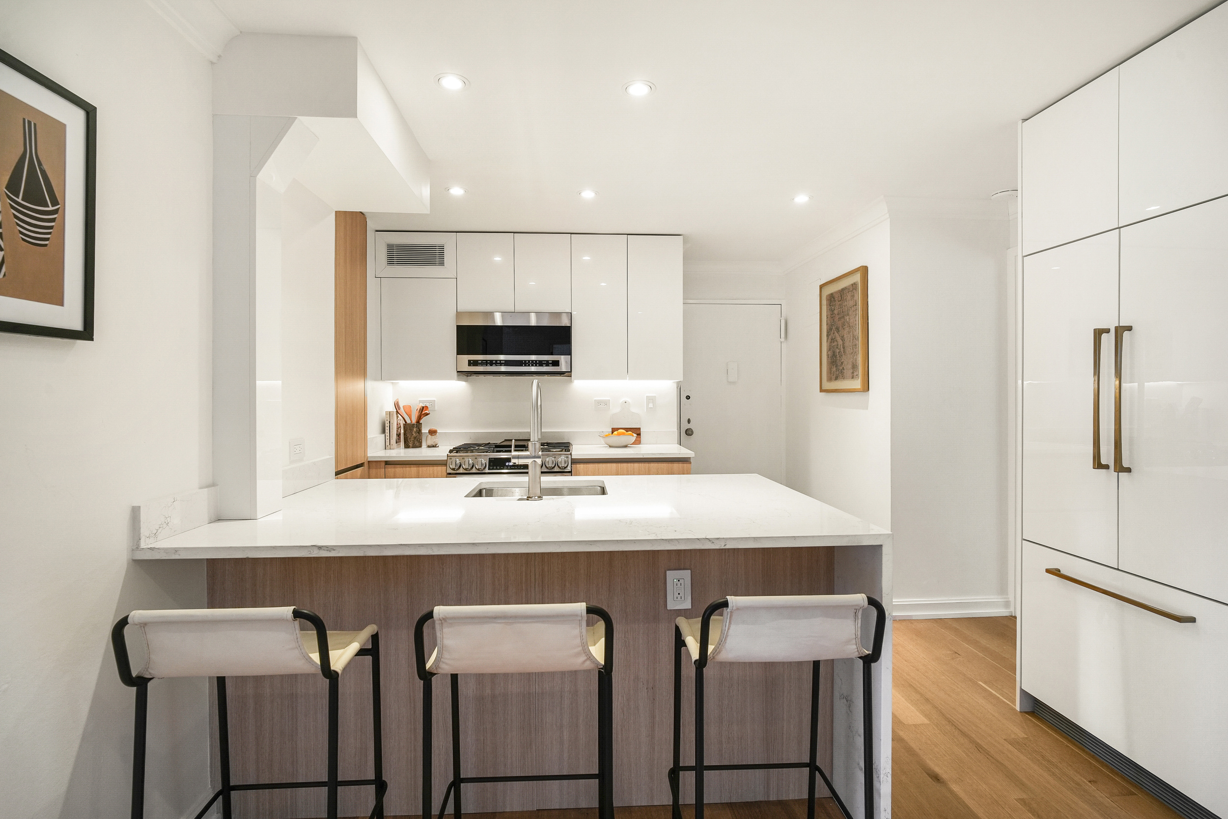 31 Jane Street, Unit 10FG Manhattan, NY 10014 - Photo 10 of 27 a kitchen with appliances cabinets and wooden floor