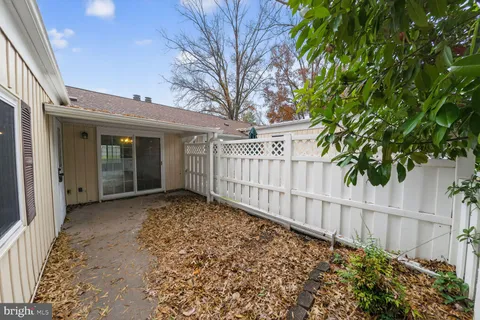 a view of a house with a small yard and wooden fence
