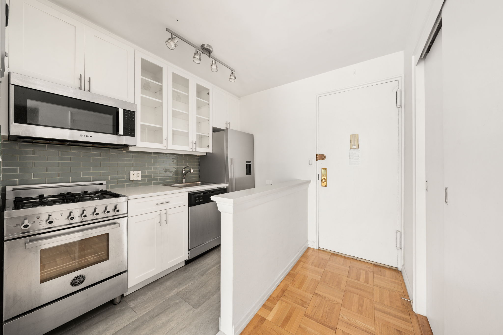 139 East 33rd Street, Unit 10D Manhattan, NY 10016 - Photo 7 of 13 a kitchen with stainless steel appliances granite countertop white cabinets a stove top oven a sink and dishwasher