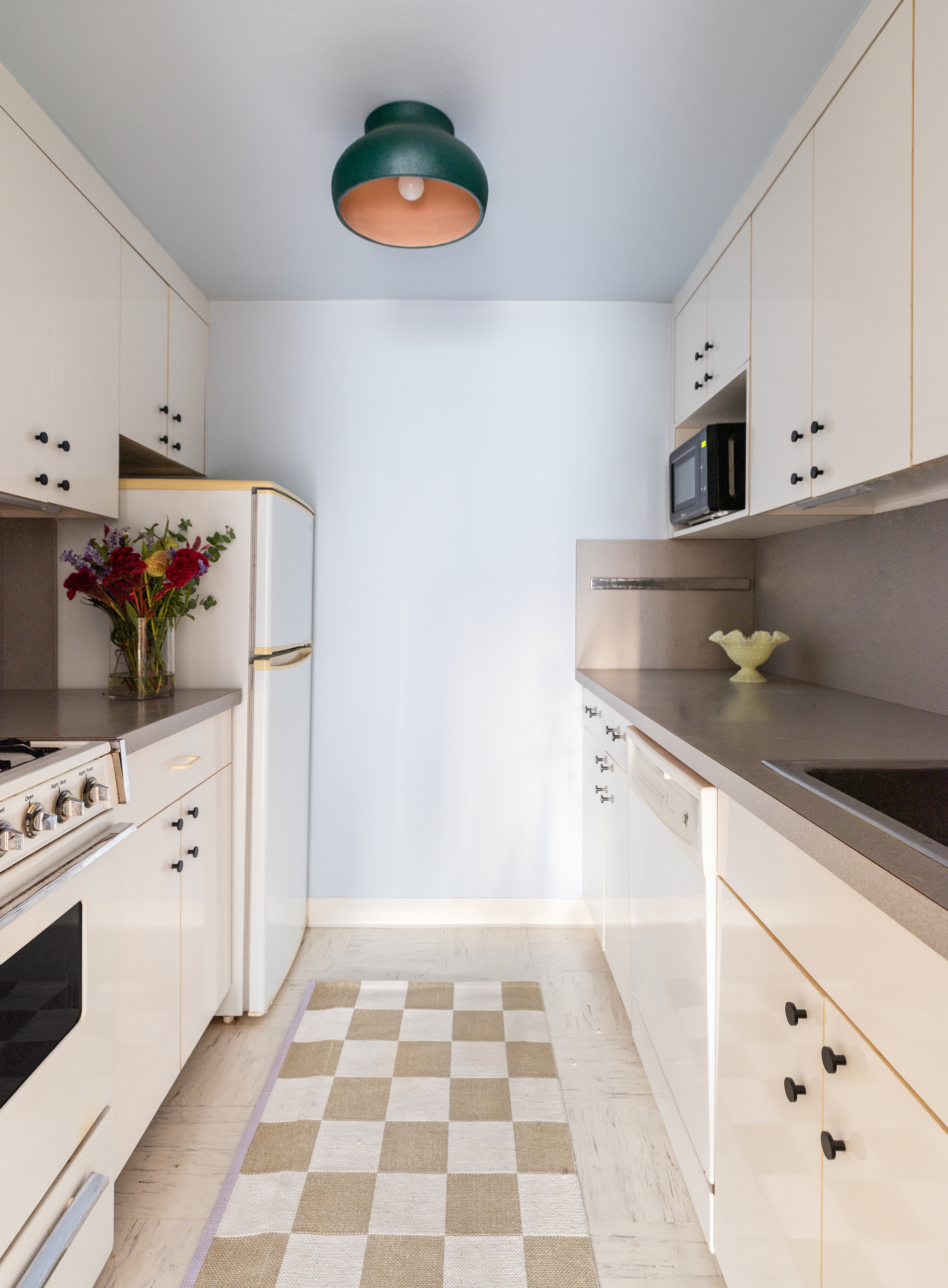 10 East End Avenue, Unit 18E Manhattan, NY 10075 - Photo 5 of 13 a kitchen with stainless steel appliances a stove a sink and a refrigerator