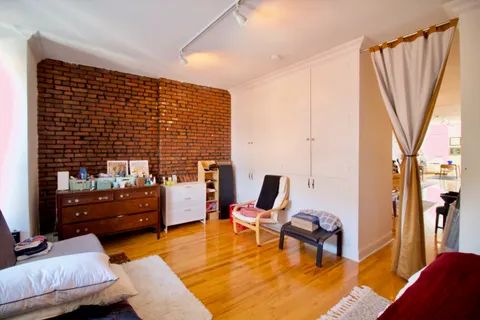 a bedroom with furniture and a wooden floor