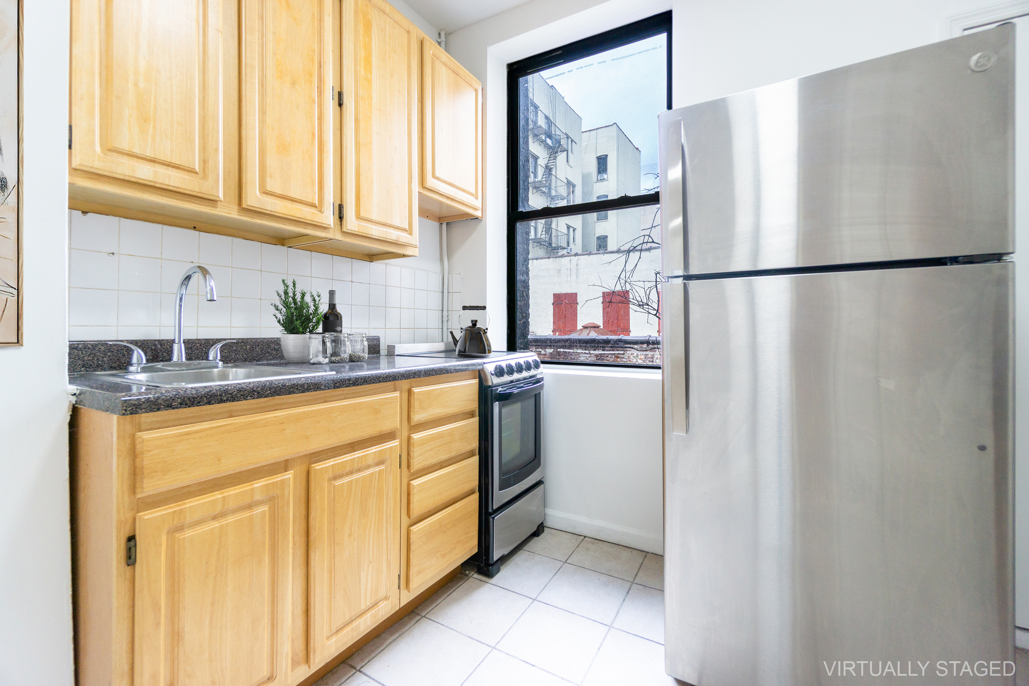 215 East 5th Street, Unit 3 Manhattan, NY 10003 - Photo 17 of 25 a kitchen with stainless steel appliances granite countertop a refrigerator sink and cabinets
